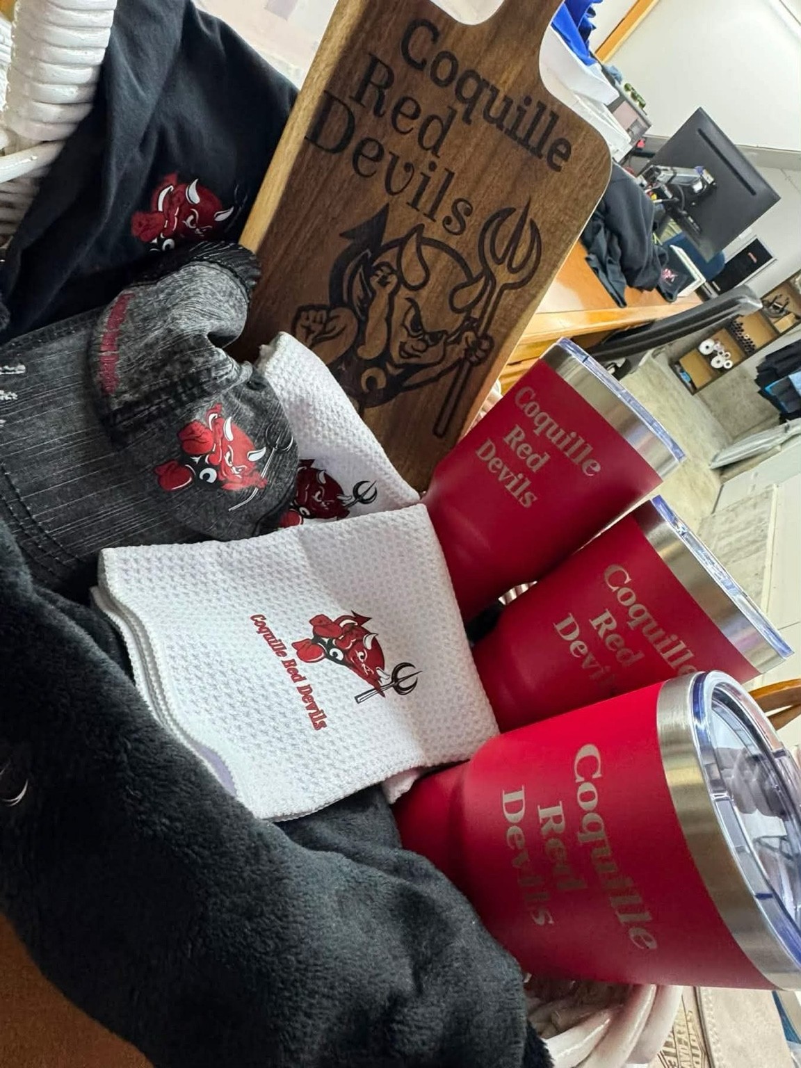 Custom collection featuring apparel, personalized hats, engraved tumblers and an engraved wooden board