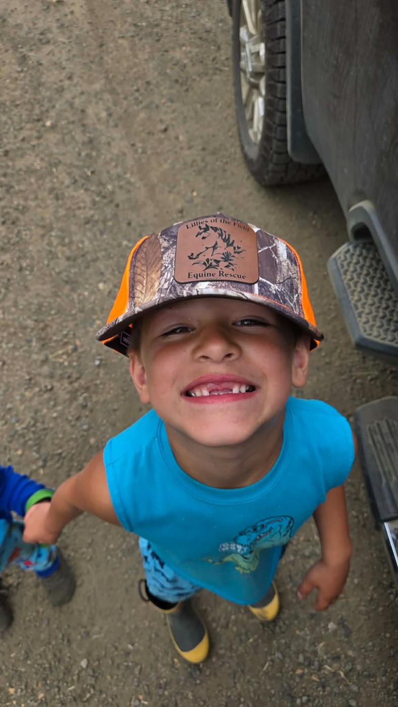 Child wearing personalized camouflage hat with custom leather patch